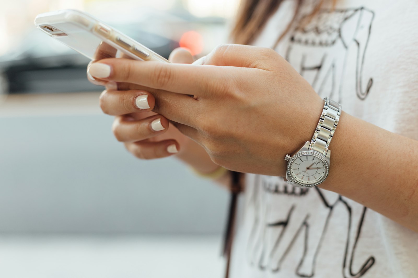 A close-up of a hand holding a smartphone while typing a text message