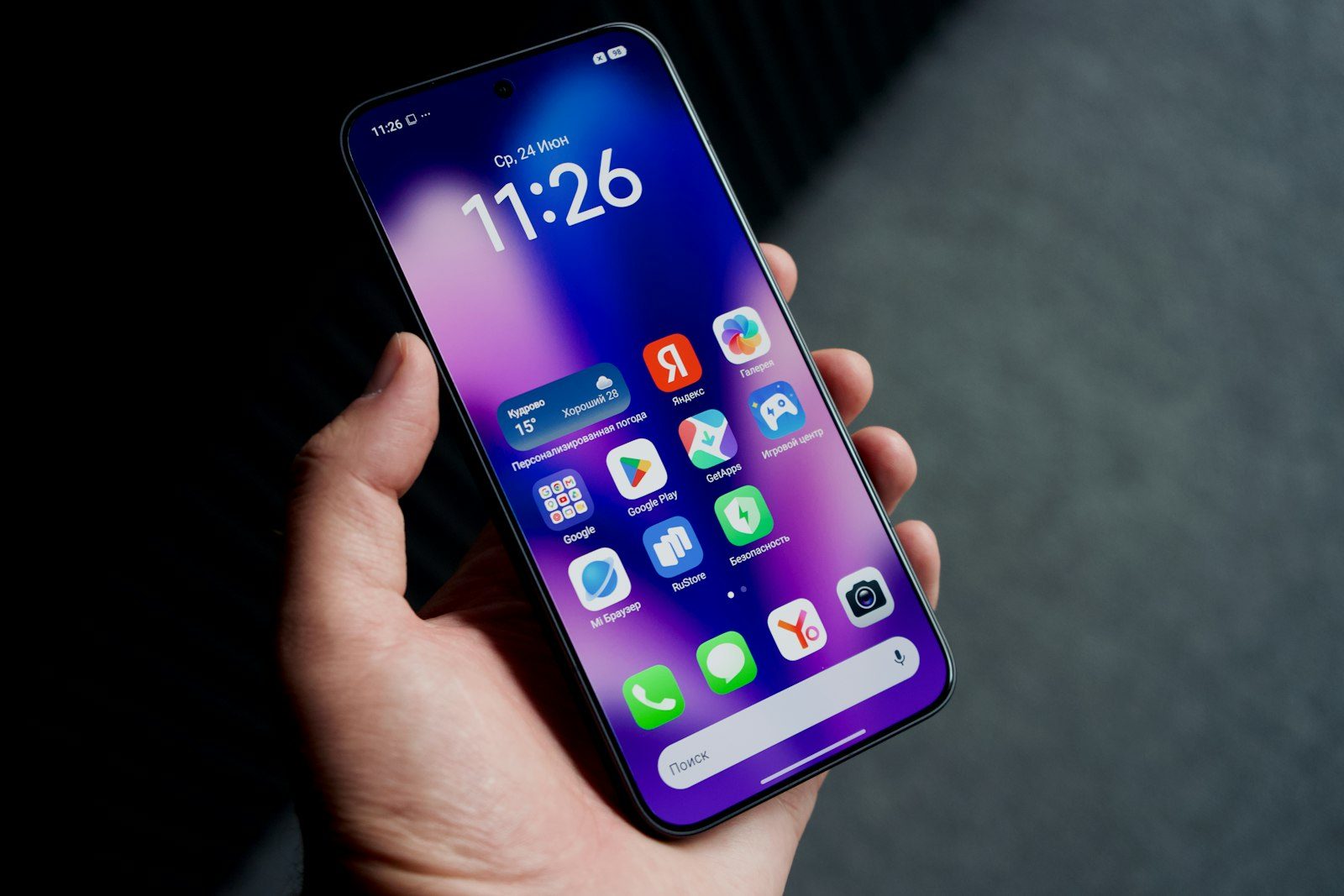 A hand holding a smartphone with a screen full of colorful app icons
