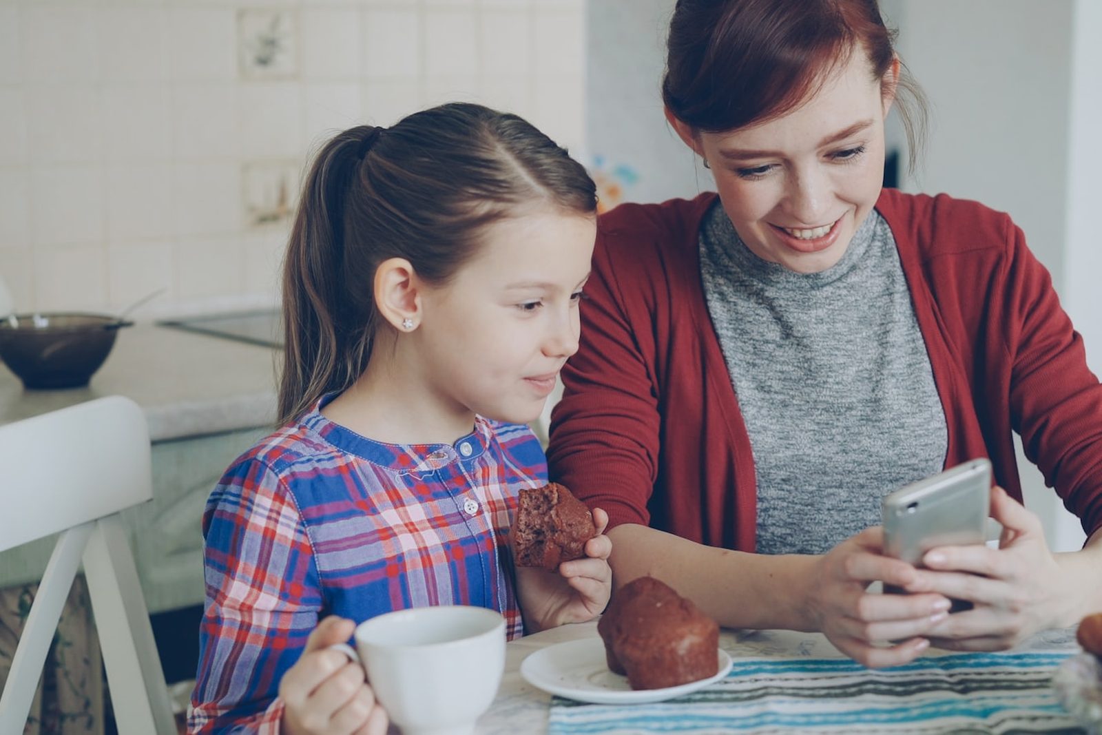 A mother and daughter looking at a phone together